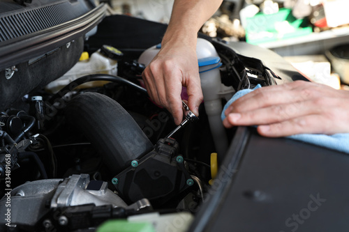 Professional auto mechanic fixing modern car in service center  closeup