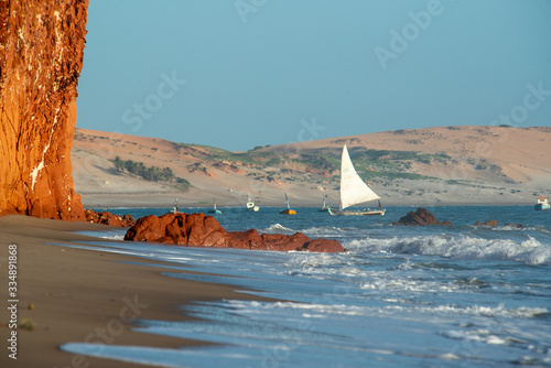 Colorful cliffs, dunes and small sailing boat early morning on the beach of Peroba, Icapui, Ceará, Brazil on April 23, 2016 photo