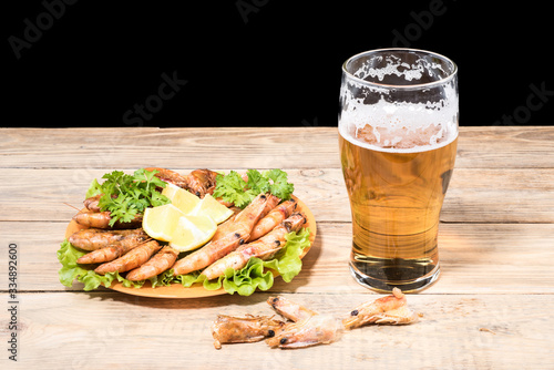 Glass with light beer on a wooden table.