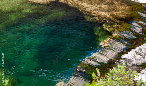 Fototapeta Naklejka Na Ścianę i Meble -  Stones under the surface of a small waterfall with clear turquoise water in Huancaya town, Lima Region, Peru