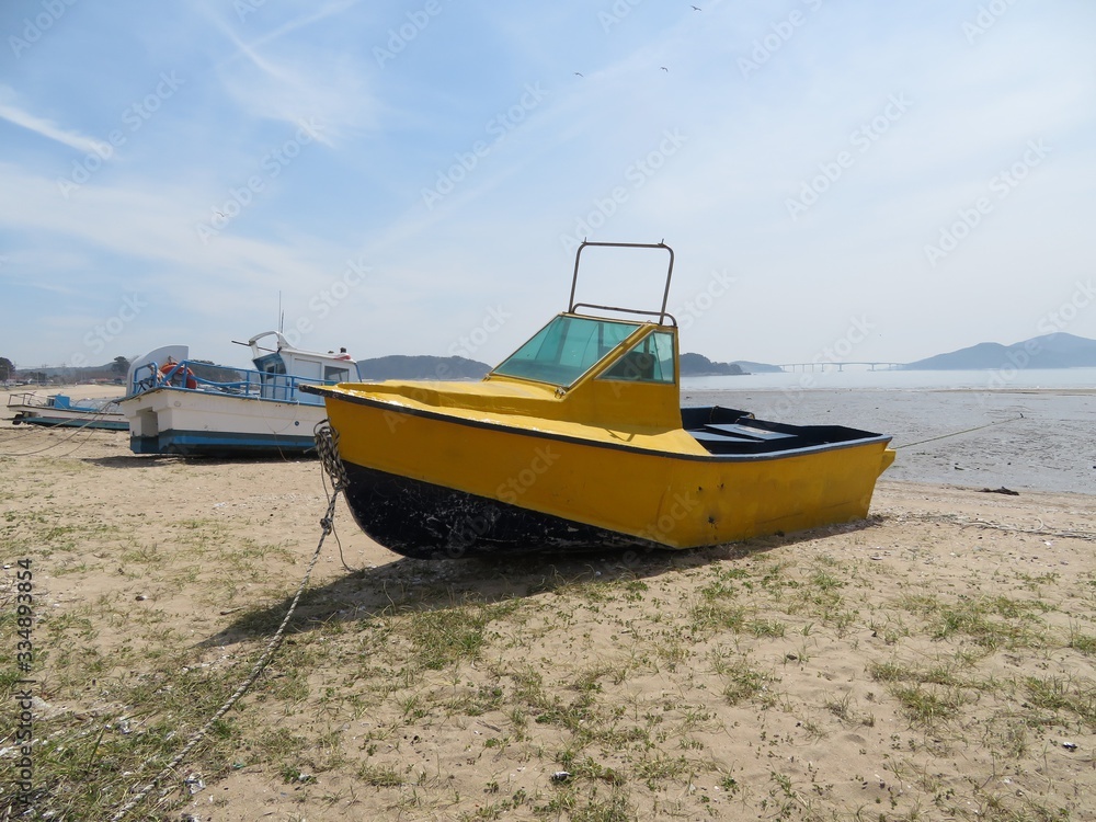 Eclectic yellow motorboat on a sandy beach in Incheon, Korea Eclectic yellow motorboat on a sandy beach in Incheon, Korea