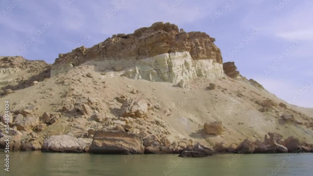 Tracking shot from inside water of sandy cliffs of an exotic beautiful remote empty beach