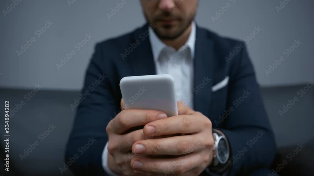 cropped view of businessman texting on smartphone cropped view of businessman texting on smartphone