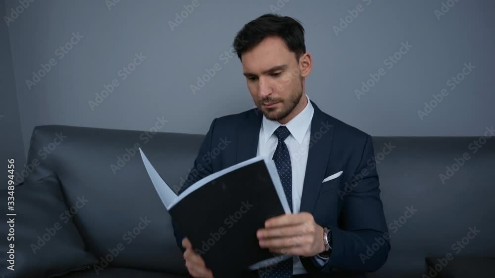 handsome businessman looking at documents in folder handsome businessman looking at documents in folder