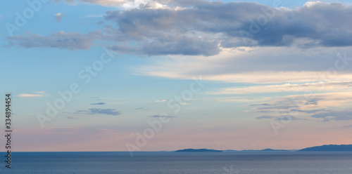 sunset over the sea, hills on the horizon © Юрий Якименко