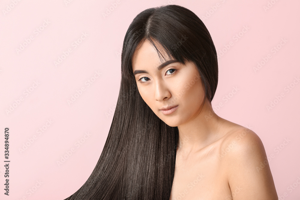 Fototapeta premium Young Asian woman with beautiful long hair on color background