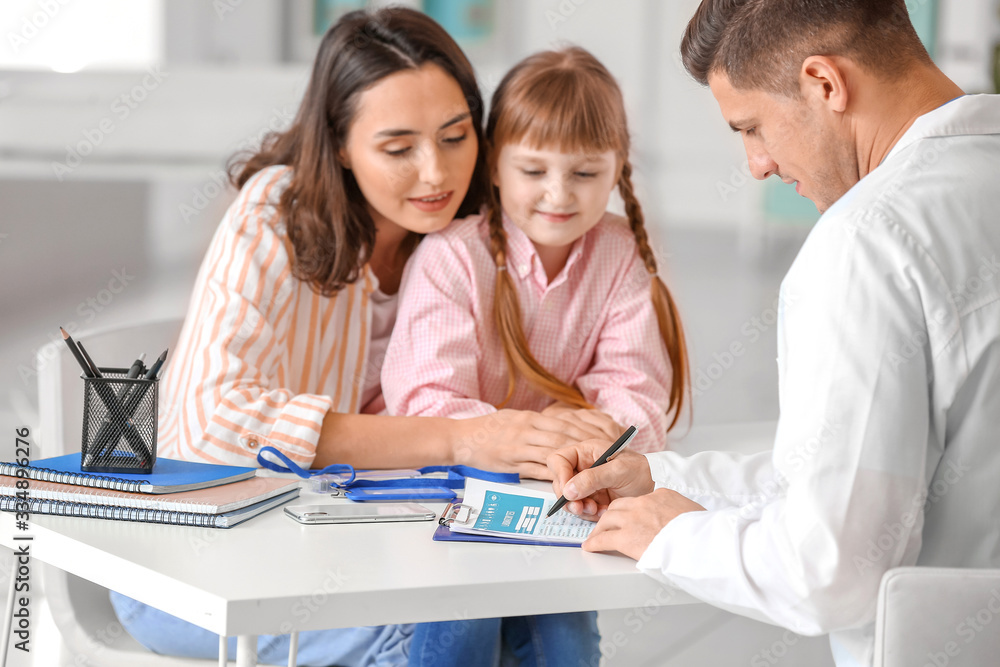 Woman with little daughter visiting pediatrician in clinic Woman with little daughter visiting pediatrician in clinic