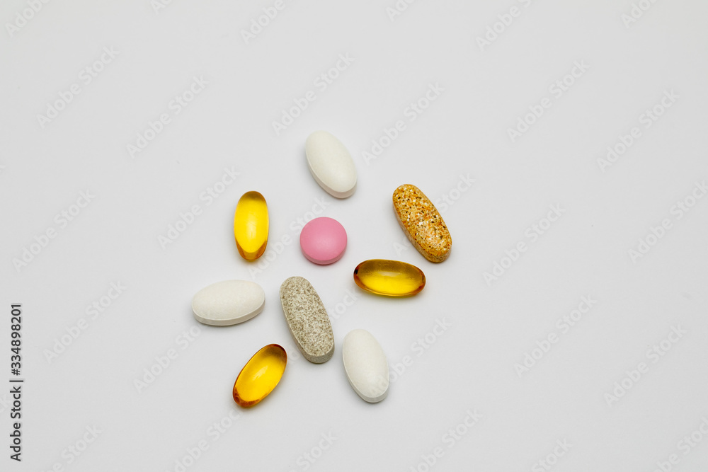 Capsules and tablets of different colors and shapes on a white background. Vitamins, Sports nutrition. Top view Capsules and tablets of different colors and shapes on a white background. Vitamins, Sports nutrition. Top view