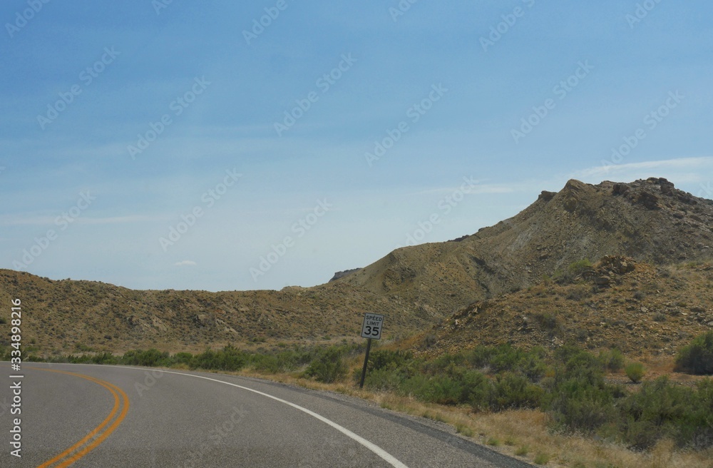 Winding road with a speed limit sign on the roadside to Montana just a few miles from Wyoming state line.