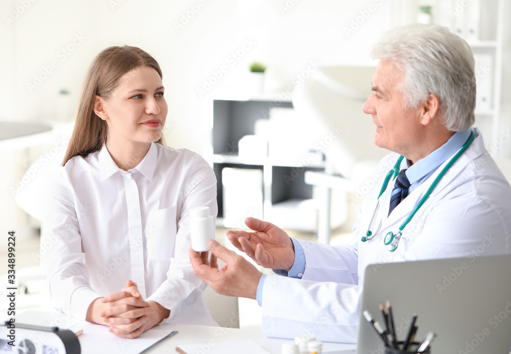 Doctor giving pills to patient in clinic Doctor giving pills to patient in clinic