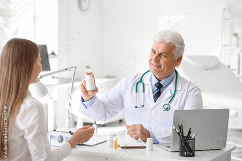 Doctor giving pills to pati...