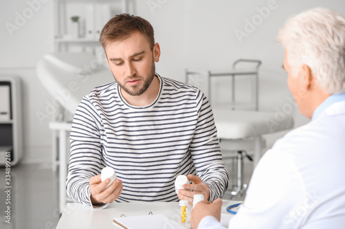 Doctor giving pills to patient in clinic