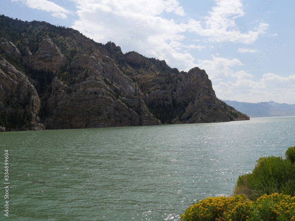 Water flowing at the Buffalo Bill Reservoir and Dam in Wyoming, bordered by scenic rock and geologic formations in Wyoming.