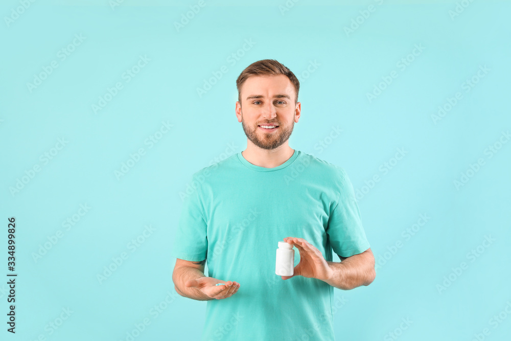Young man with pills on color background Young man with pills on color background