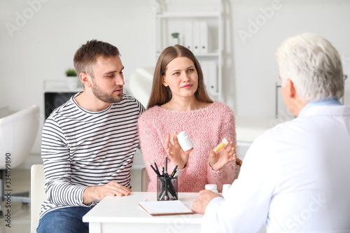 Doctor giving pills to youn...