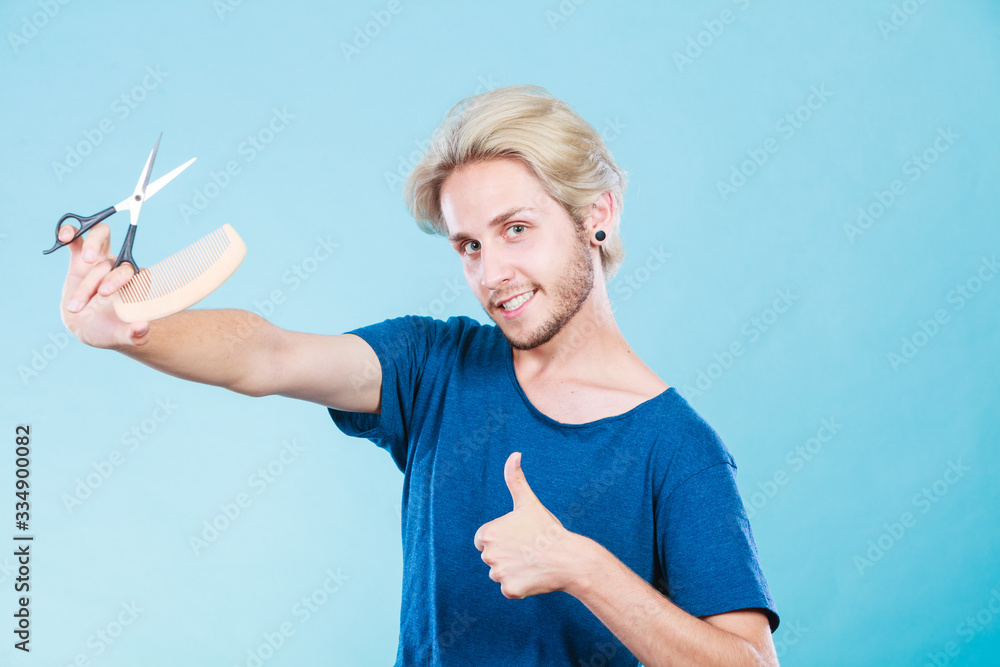 Man with scissors and comb creating new coiffure Man with scissors and comb creating new coiffure