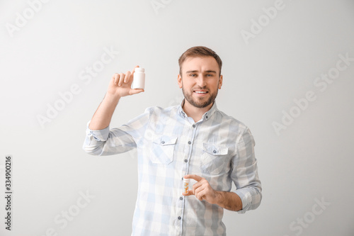 Young man with pills on lig...