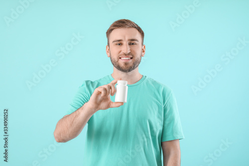 Young man with pills on col...