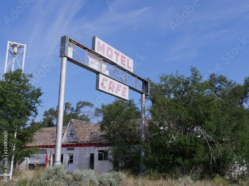 Glenrio, New Mexico- August 2018: Front view of a dilapidated motel and cafe covered by trees at Glenrio, one of America's ghost towns. photo