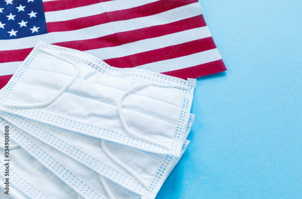 Medical masks with flag of USA on blue background. Mask for protection from dust, pollution, viruses. Flat lay, top view, mock up. Medical masks with flag of USA on blue background. Mask for protection from dust, pollution, viruses. Flat lay, top view, mock up.