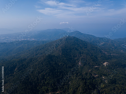  Aerial view of the peaks of the mountains covered with rainforest at sunrise, soft light
