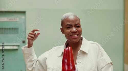 Slow motion of woman singing and misusing red pepper as microphone photo