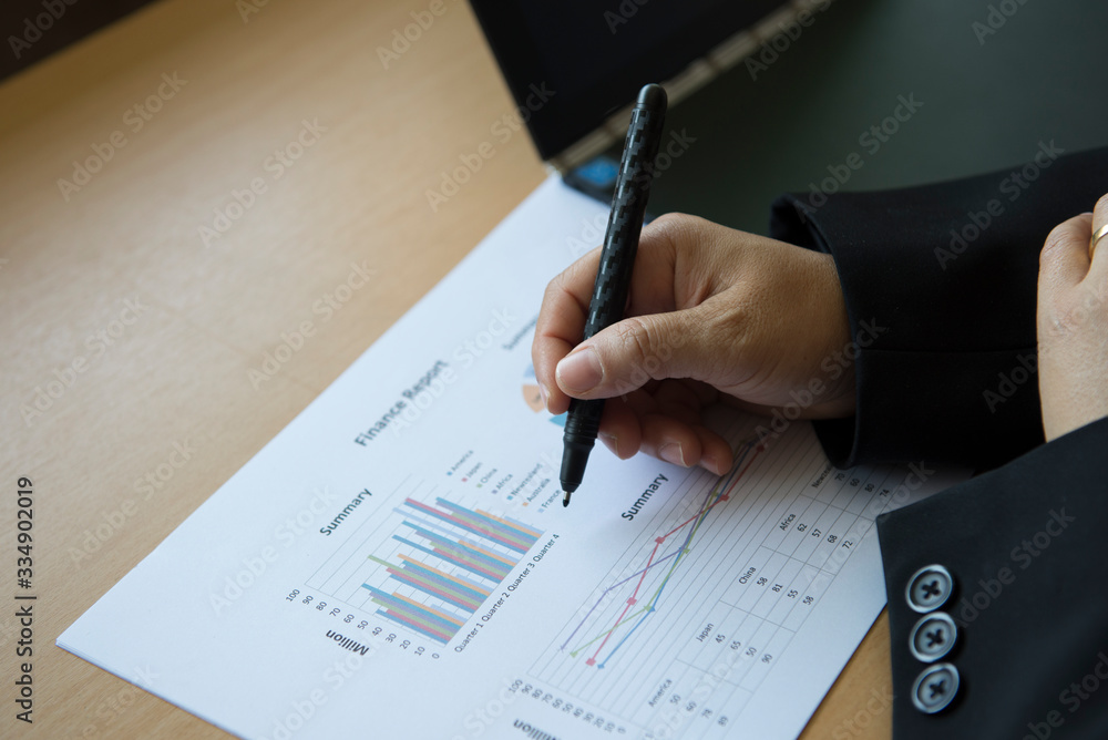 Close shot of a human hand writing something on the paper and look at graphy. Close shot of a human hand writing something on the paper and look at graphy.