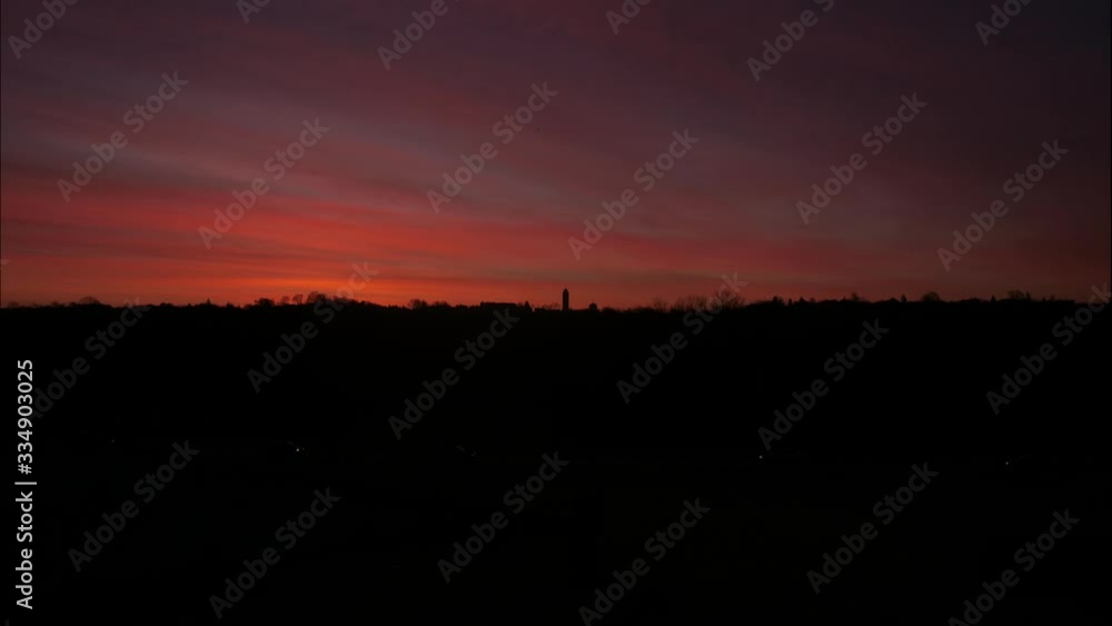 Time lapse of a red sky over the city of Kaunas as the sun rises changing it to orange and then yellow and blue Time lapse of a red sky over the city of Kaunas as the sun rises changing it to orange and then yellow and blue