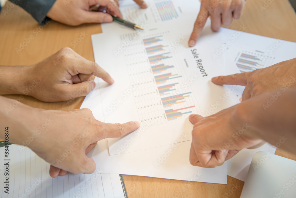 Group of business teamwork point finger to the business report. Concept of business succession.In selective focus of finger. Group of business teamwork point finger to the business report. Concept of business succession.In selective focus of finger.