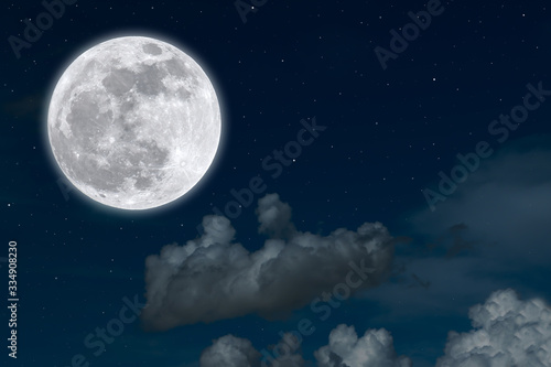 Full moon with clouds on blue sky.