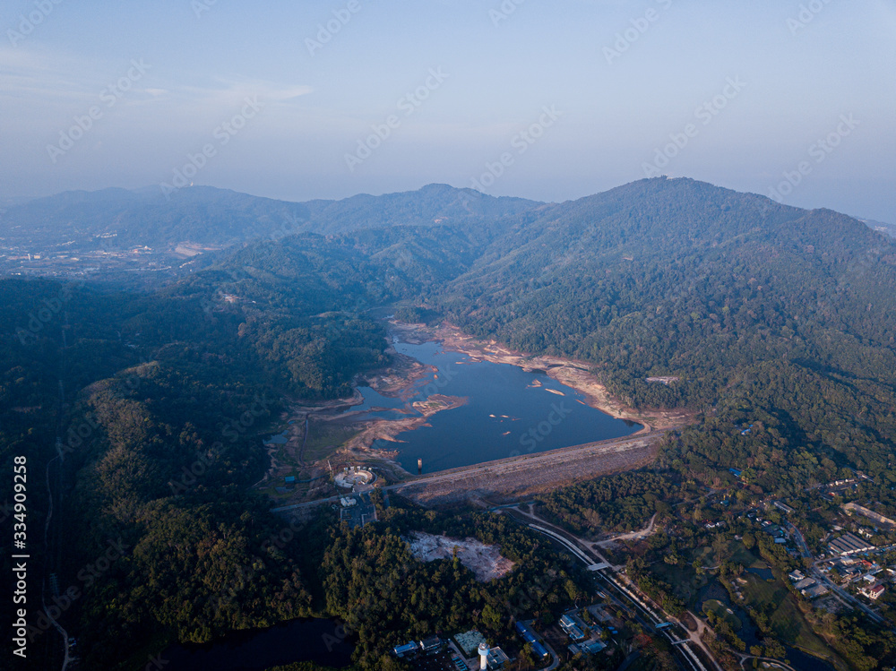 Fototapeta premium A dry dam due to the lack of rain in Thailand. Beautiful lake at sunrise located between the hills and golf courses
