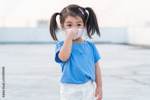 A little girl wearing mask for prevent the spread of the Covid-19, Covic 19 virus protection concept in Thailand. photo