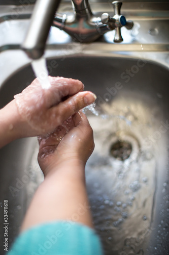 Wash hands with soap. Female hands under a kitchen faucet