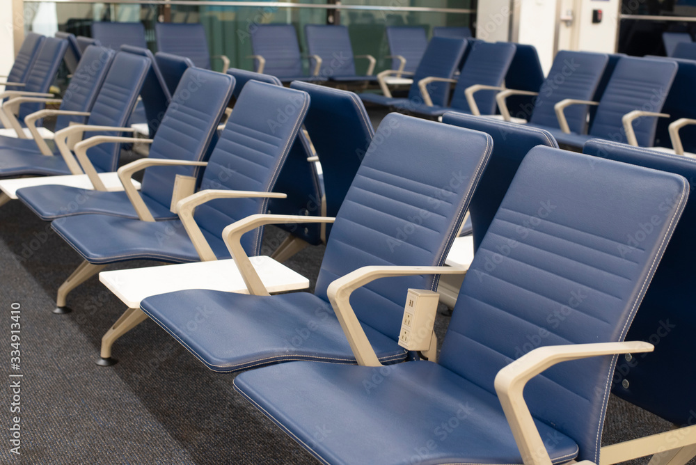 Obraz premium Row of empty blue chairs in an airport waiting area.