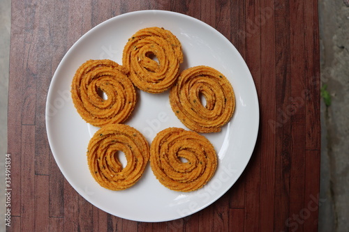 Indian Traditional Snack Chakali, a spiral shaped crisp deep fried snack, It is known as Chakali, Murukku, Muruku, Murkoo, Chakri in Gujarat, Chakli in Maharashtra, Indian festival or Diwali Snacks  photo