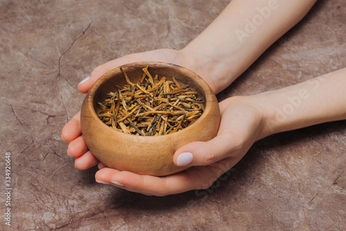 Woman holds in a bowl with tea buds photo