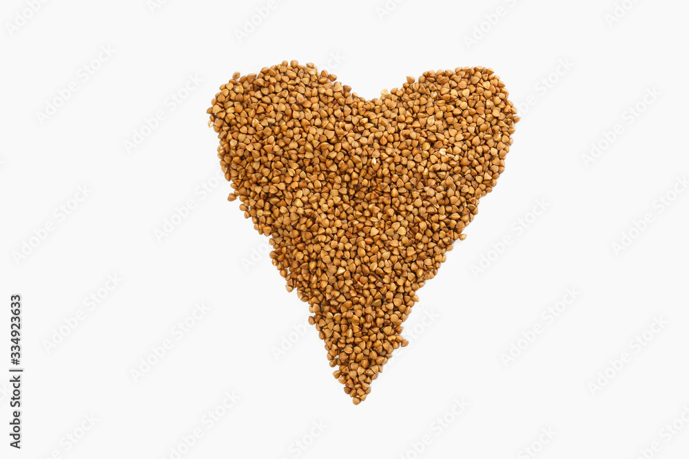 
Buckwheat groats are laid out on a white background in the form of a heart. Favorite groats in Russia.