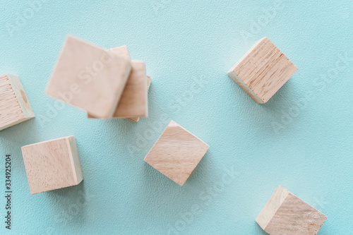 Wooden cubic on plastel color background. photo