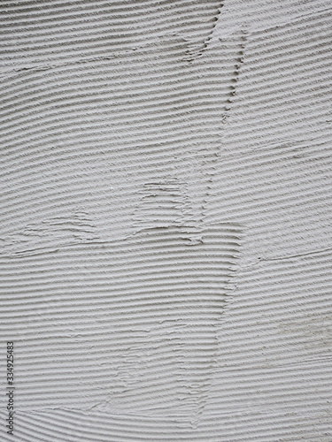 striped pattern made on a gray cement wall as a preparation for brickwork