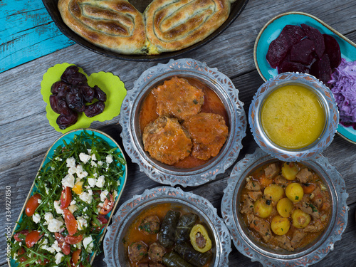 Eid Mubarak Traditional Ramadan Iftar dinner. Assorted tasty food in authentic rustic dishes on wooden table background. photo