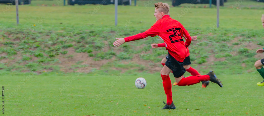 Junger Fußballspieler bei einem Fußballspiel in Aktion Junger Fußballspieler bei einem Fußballspiel in Aktion