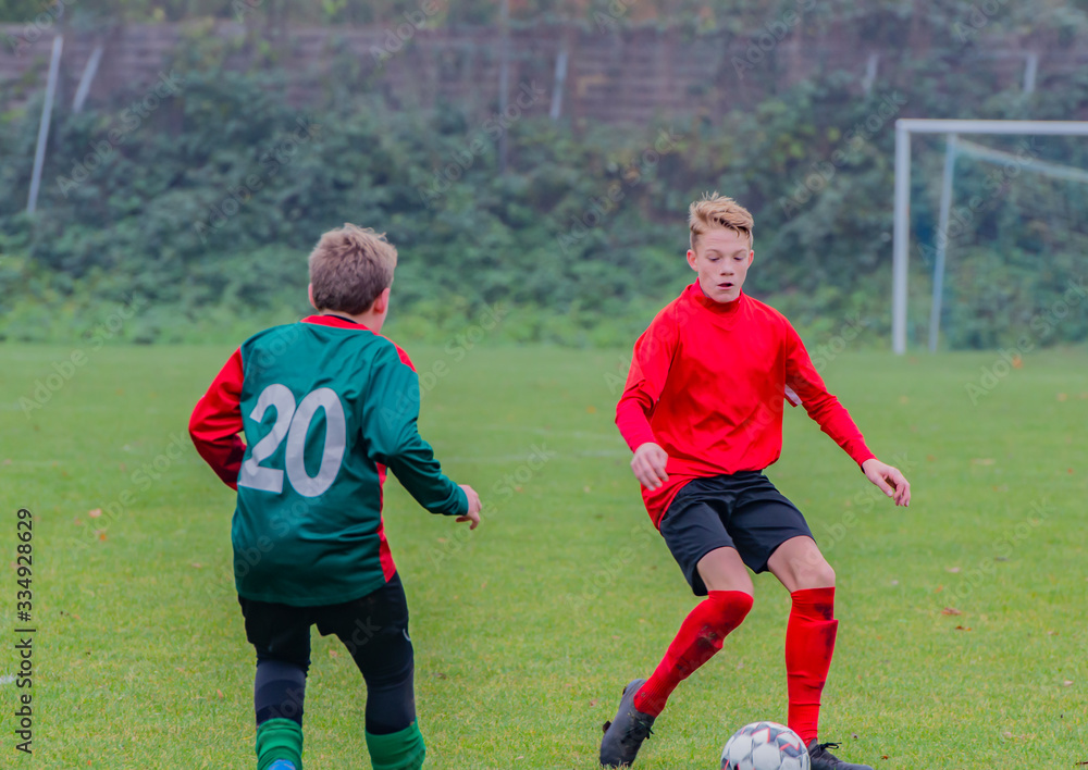 Junger Fußballspieler bei einem Fußballspiel in Aktion Junger Fußballspieler bei einem Fußballspiel in Aktion