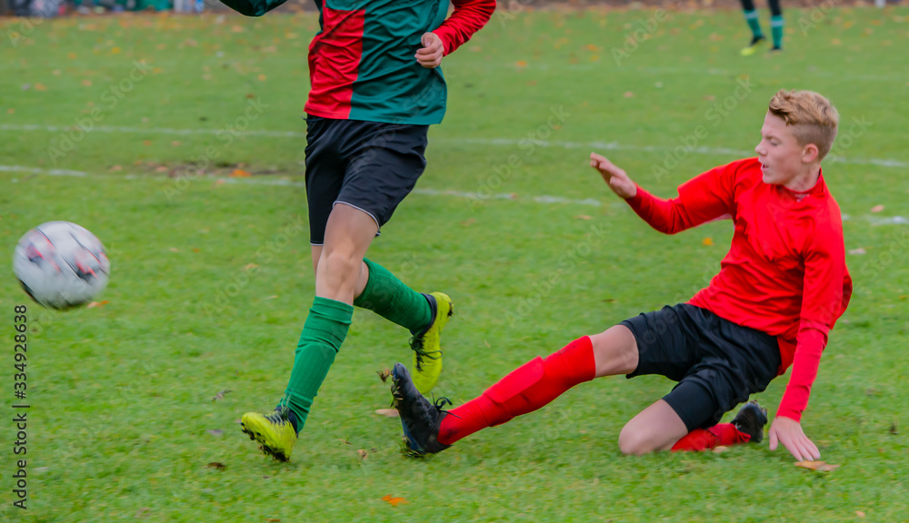 Junger Fußballspieler bei einem Fußballspiel in Aktion Junger Fußballspieler bei einem Fußballspiel in Aktion
