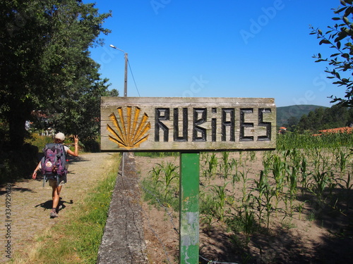 Pilgrim walking with wooden signboard with the inscription 