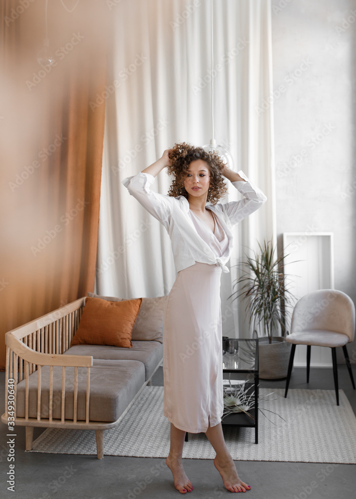 Beautiful gentle elegant curly cute girl in a light spring dress resting relaxing, enjoying herself, having fun alone at home, tenderness, self-care self-love Beautiful gentle elegant curly cute girl in a light spring dress resting relaxing, enjoying herself, having fun alone at home, tenderness, self-care self-love