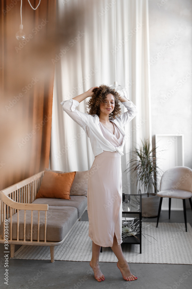 Beautiful gentle elegant curly cute girl in a light spring dress resting relaxing, enjoying herself, having fun alone at home, tenderness, self-care self-love Beautiful gentle elegant curly cute girl in a light spring dress resting relaxing, enjoying herself, having fun alone at home, tenderness, self-care self-love