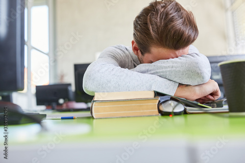 Fatigue student sleeps on his desk photo