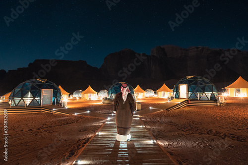A man stading in front of martian dome tents in Wadi Rum Desert, Jordan