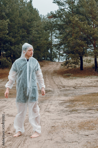 Wallpaper Mural A man in a white protective overalls on a sandy road. Protective suit against the virus. Torontodigital.ca