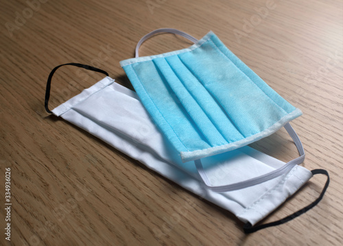 blue and white protective masks lie on a wooden table